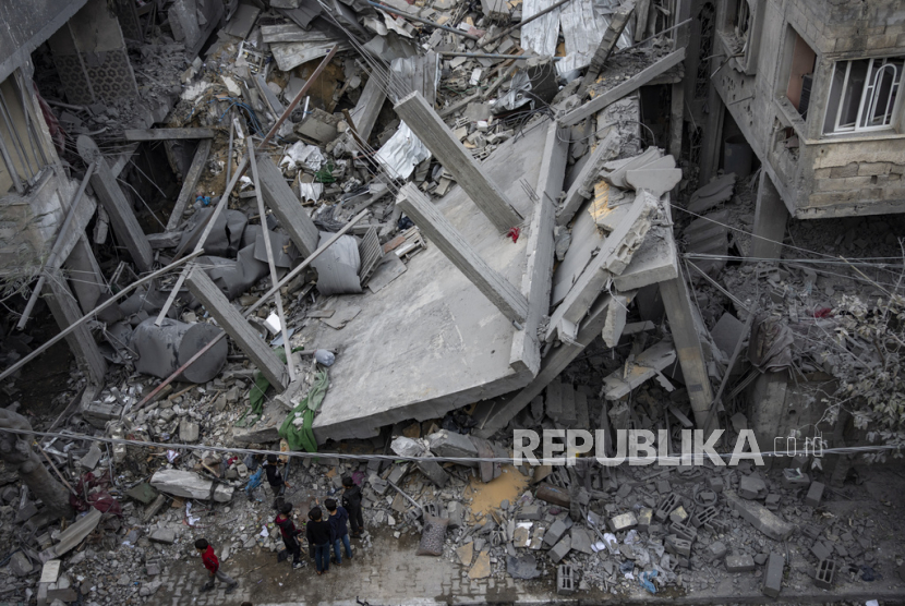 Warga Palestina memeriksa kerusakan bangunan tempat tinggal pasca serangan udara Israel di Rafah, Jalur Gaza selatan, Ahad, (24/3/2024).