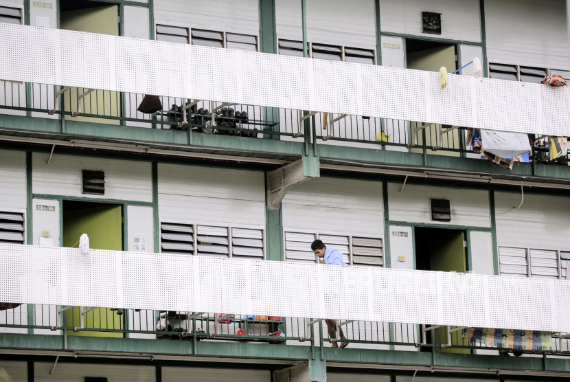 Pekerja berjalan di koridor asrama pekerja asing Cochrane Lodge II, Singapura, Selasa (28/4). Kasus Virus Corona di Singapura sudah hampir mencapai 15 ribu