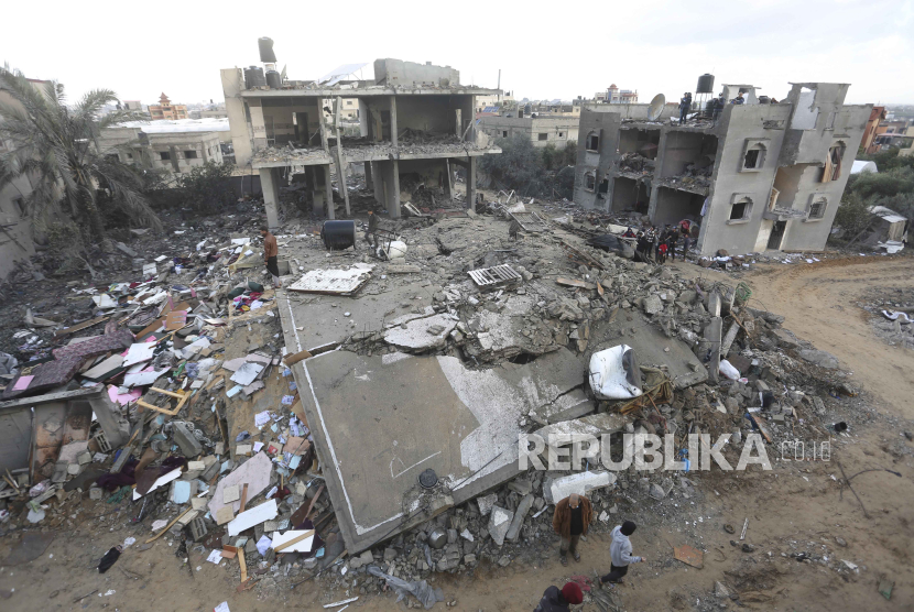 Palestinians look at houses destroyed in the Israeli bombardment of the Gaza Strip in Rafah on Monday, Nov. 20, 2023.