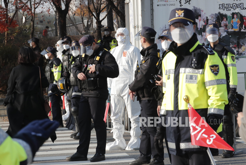  Petugas polisi yang mengenakan masker wajah dan perisai untuk membantu melindungi dari penyebaran virus corona berjaga-jaga saat para pekerja mengadakan unjuk rasa untuk menuntut kondisi kerja yang lebih baik di Seoul, Korea Selatan, Sabtu, 14 November 2020. 