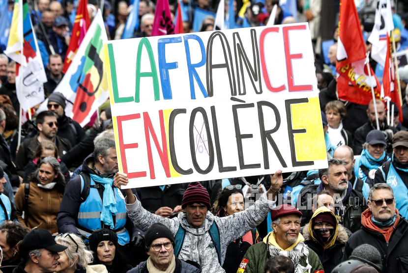  File foto seorang pengunjuk rasa memegang papan bertuliskan Angry France berpartisipasi dalam protes menentang reformasi pensiun pemerintah di Paris, Prancis, pada 28 Maret 2023.