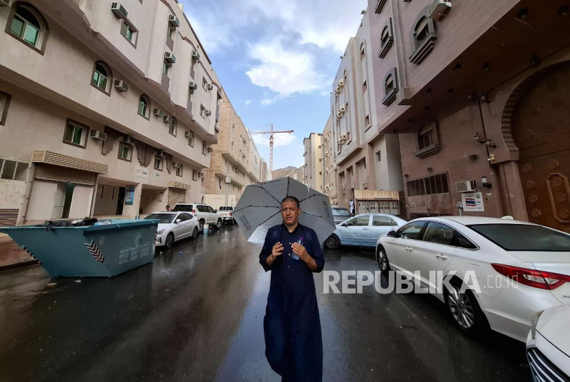 Warga Arab Saudi memakai payung saat Kota Mekkah diguyur hujan, Senin (17/6/2024). Kota Mekkah diguyur hujan deras. Peristiwa langka itu terjadi pada Senin (17/6/2024) pukul 16.00 Waktu Arab Saudi (WAS), bersamaan dengan jamaah haji melakukan mabit di Mina dan melontar jumroh. Warga Saudi menyambut hujan dengan turun ke jalan sembari berdoa.