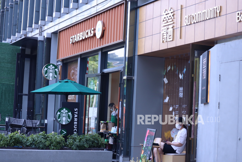 Para pelayan kafe menunggu pembeli di Distrik Chaoyang, Beijing, China, Rabu (18/5/2022). Sejak 1 Mei 2022 otoritas setempat melarang warga makan dan minum di restoran dan kafe untuk memudahkan pengendalian Covid-19 varian Omicron selama lockdown parsial. 