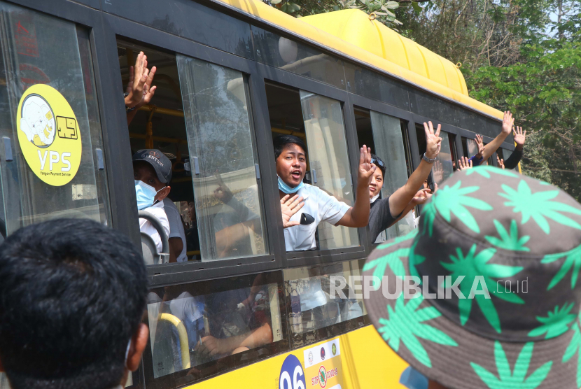 Pengunjuk rasa yang ditangkap memberikan hormat tiga jari saat berada di dalam bus yang keluar dari penjara Insein dan akan mengangkut mereka ke lokasi yang dirahasiakan pada Rabu (24/3). di Yangon, Myanmar.