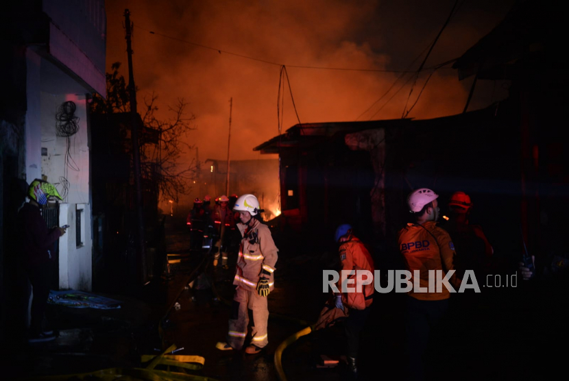 Petugas pemadam kebakaran berusaha memadamkan kobaran api akibat pipa bensin di area Terminal Bahan Bakar Minyak (TBBM) Plumpang yang terbakar di Jakarta Utara, Jumat (3/3/2023) malam.