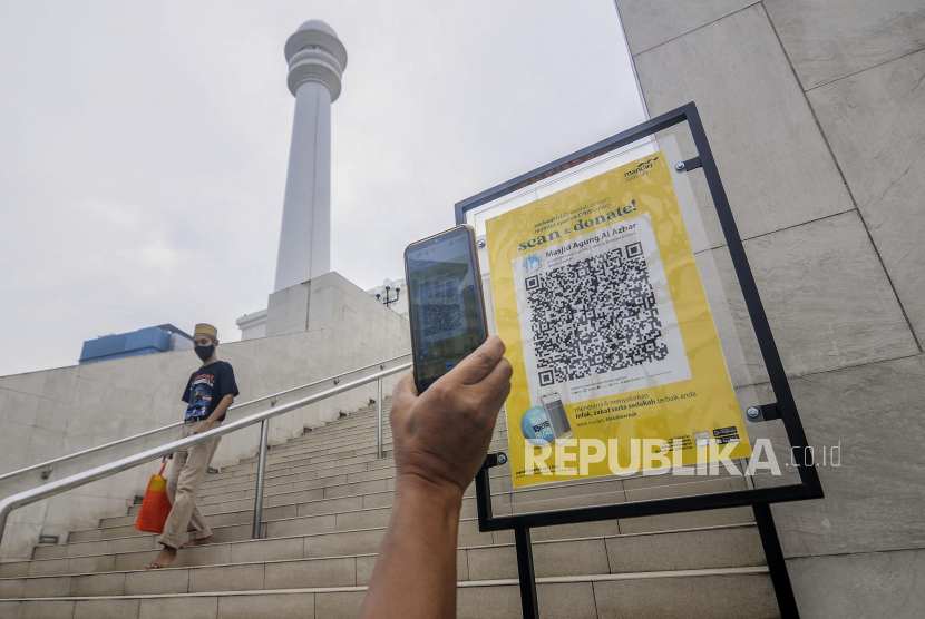 Warga memindai QR Barcode untuk membayar zakat di Masjid Agung Al-Azhar, Jakarta.