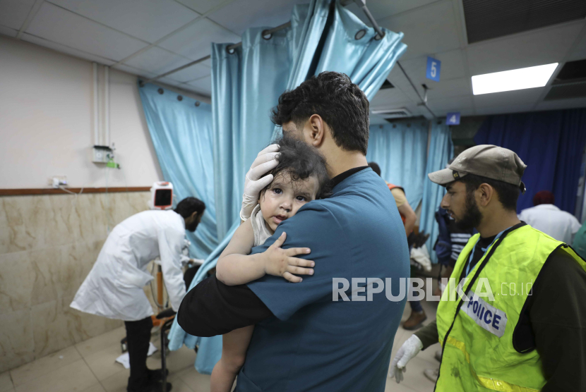 Petugas medis Palestina menggendong seorang anak yang terluka dalam serangan udara Israel di Jalur Gaza, di Deir el-Balah, Ahad (22/10/2023). Dilansir Reuters, serangan udara Israel ke Gaza sejak 7 Oktober 2023 telah mengakibatkan 4.651 warga Palestina meninggal dunia, 40 persen di antaranya adalah anak-anak.