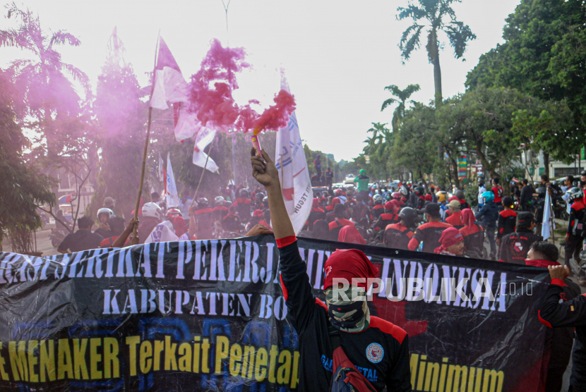 Pengunjukrasa dari berbagai aliansi buruh melakukan aksi tutup jalan saat unjuk rasa di depan Kantor Pemerintah Daerah Kabupaten Bogor, Cibinong,  Bogor, Jawa Barat, Kamis (25/11/2021). Mereka menuntut kenaikan Upah Minimum Kabupaten (UMK) 2022 sebesar 10 persen dan menolak omnibuslaw. 