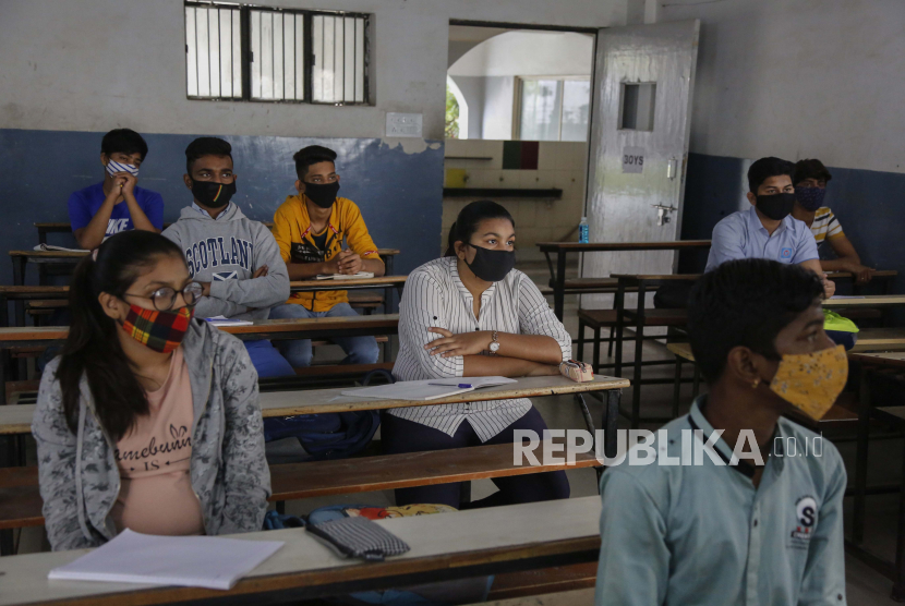 Siswa yang mengenakan masker wajah sebagai tindakan pencegahan terhadap virus corona menghadiri kelas saat sekolah dibuka kembali setelah ditutup selama berbulan-bulan karena pandemi COVID-19 di Ahmedabad, India, Senin, 11 Januari 2021.
