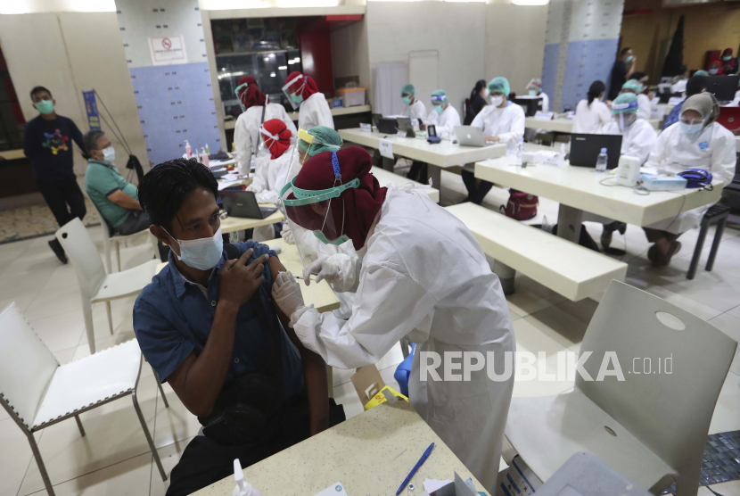  Seorang pria menerima suntikan vaksin COVID-19 saat vaksinasi massal untuk pedagang di Pasar Tanah Abang di Jakarta, Indonesia, Kamis, 18 Februari 2021. 