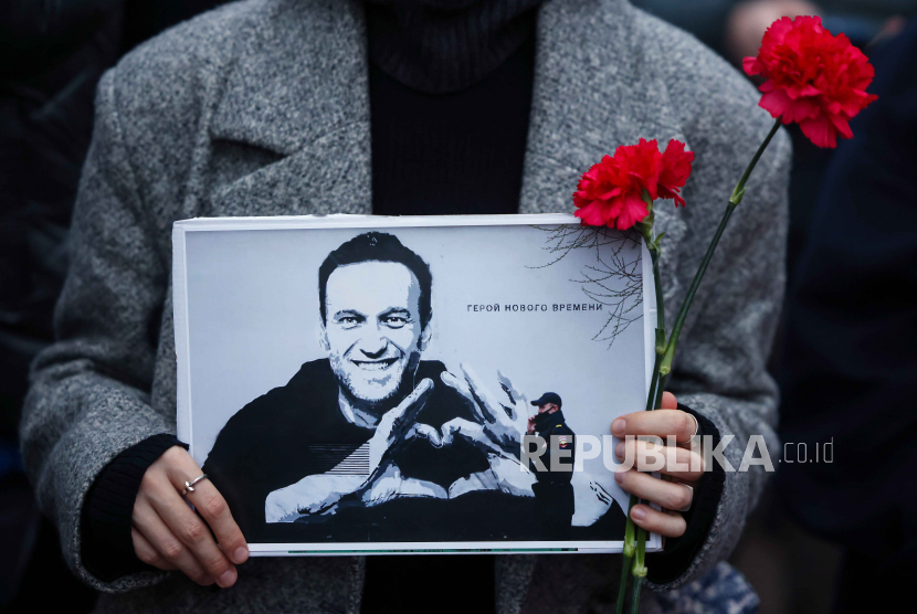 Pengunjuk rasa memegang potret pemimpin oposisi Rusia, Alexei Navalny di depan Kedubes Rusia di Berlin, Jerman, 16 Februari 2024. 