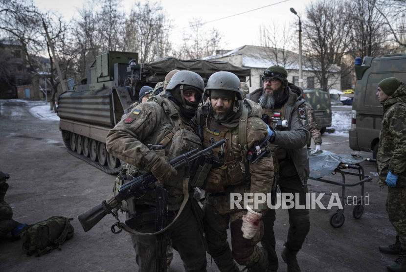 Seorang prajurit Ukraina membawa rekannya yang terluka yang dievakuasi dari medan perang ke sebuah rumah sakit di wilayah Donetsk, Ukraina.