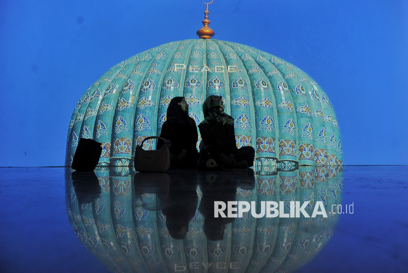 Pengunjung berfoto dengan latar belakang layar yang menampilkan karya seni dan narasi budaya Islam pada Pameran Imersif Islam di Nusantara & Imam Bukhari: Islamic Art di Galeri Harmoni Istiqlal, Jakarta, Jumat (3/1/2025). Pameran tersebut menyajikan beragam karya dalam bentuk dua dimensi dan imersif interakti yang menjelaskan tentang sejarah dan budaya islam di nusantara, cipta kawasan dan Masjid Istiqlal, serta menyajikan sejarah tentang Imam Bukhari dan kota kelahirannya yang sarat nilai toleransi dan harmoni Islam. Pameran tersebut diselenggarakan pada 10 Desember 2024 hingga 28 Februari 2025 dari pukul 09.00 sampai 21.00 dengan harga tiket untuk pelajar Rp35.000 dan umum Rp45.000.