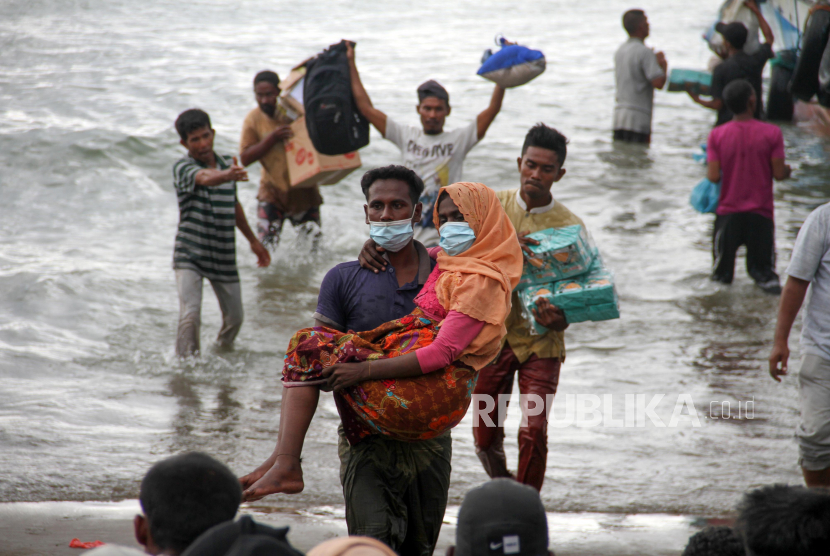 Warga melakukan evakuasi paksa pengungsi etnis Rohingya dari kapal di pesisir pantai Lancok, Kecamatan Syantalira Bayu, Aceh Utara, Aceh, Kamis (25/6/2020). Warga terpaksa melakukan evakuasi paksa 94 orang pengungsi etnis Rohingya ke darat yang terdiri dari 15 orang laki-laki, 49 orang perempuan dan 30 orang anak-anak tanpa seizin pihak terkait, karena warga menyatakan tidak tahan melihat kondisi pengungsi Rohingya yang memprihatikan di dalam kapal sekitar 1 mil dari bibir pantai dalam kondisi. terutama anak-anak dan wanita dalam kondisi lemas akibat dehidrasi dan kelaparan. 