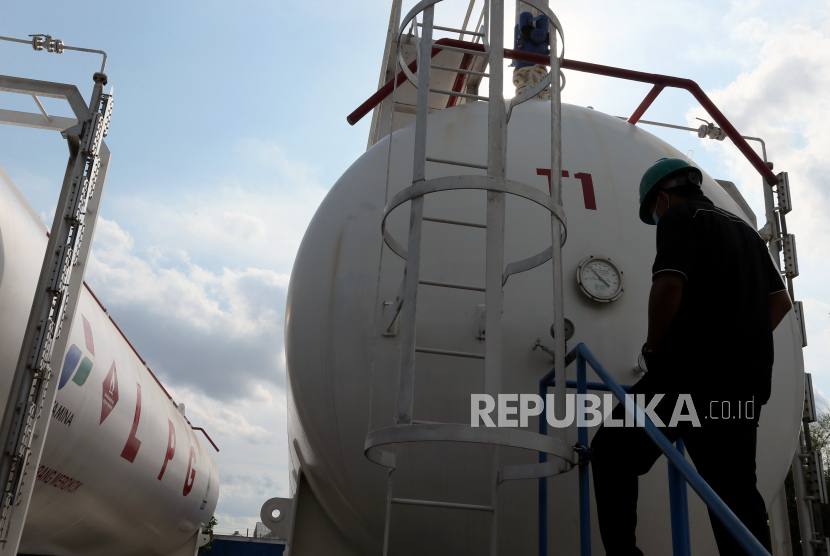 Pekerja memeriksa tangki penyimpanan elpiji di sela pelaksanaan PPKM Darurat (ilustrasi).