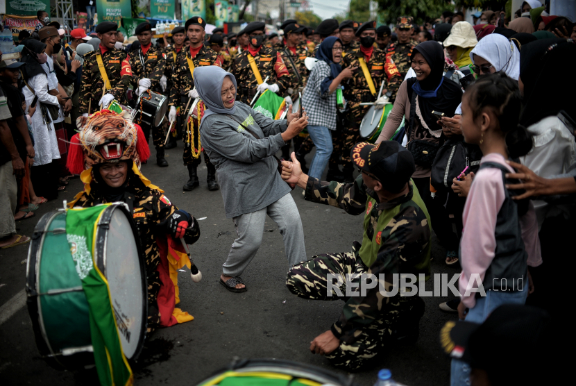 Warga berfoto saat karnaval pada acara Resepsi Puncak Satu Abad NU di kawasan Stadion Gelora Delta Sidoarjo, Jawa Timur, Selasa (7/8/2023). 