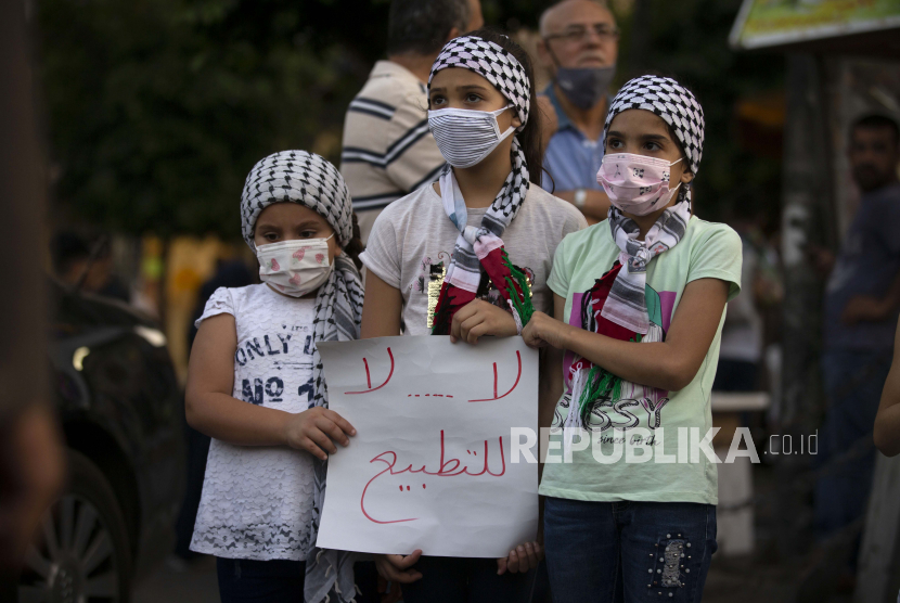  Gadis-gadis Palestina memegang tanda bertuliskan, Ganggu kesepakatan antara Uni Emirat Arab dan Israel, selama protes terhadap normalisasi hubungan antara Uni Emirat Arab dan Bahrain dengan Israel, di kota Ramallah, Tepi Barat, Selasa, September. 15, 2020. 