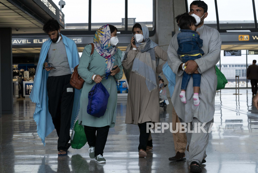 Keluarga yang dievakuasi dari Kabul, Afghanistan, berjalan melewati terminal sebelum naik bus setelah mereka tiba di Bandara Internasional Washington Dulles, di Chantilly, Va, pada Minggu, 29 Agustus 2021.