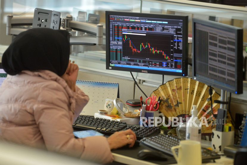 Karyawan mengamati pergerakan harga saham di Profindo Sekuritas Indonesia, Jakarta, Senin (2/1/2023). IHSG diprediksi bergerak mixed dalam rentang level 6.603–6.851 pada perdagangan Jumat (6/1/2023).