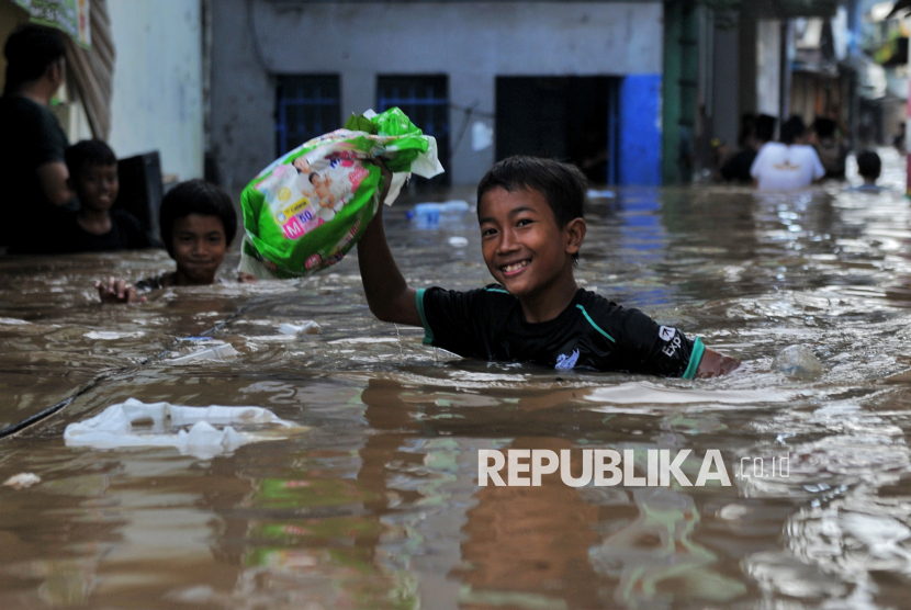 Warga mengevakuasi barang-barang dirumahnya yang terendam banjir di Kawasan Pejaten Timur, Jakarta Selatan, Senin (3/3/2025).