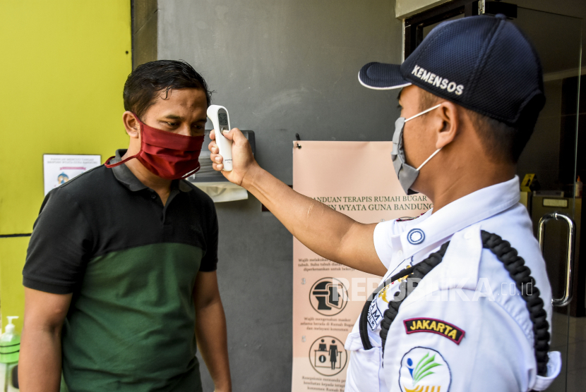 Petugas memeriksa suhu tubuh pelanggan sebelum masuk Rumah Bugar Wyata Guna Bandung, Jalan Pajajaran, Kota Bandung.