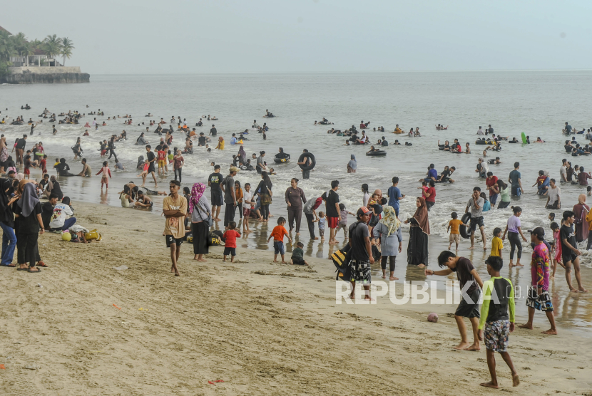 Wisatawan bermain air di Pantai Anyer, Kabupaten Serang, Sabtu (13/4/2024). Kawasan wisata tersbut menjadi favorit bagi wisatawan baik dari dalam kota maupun luar kota yang memanfaatkan waktu libur Lebaran untuk berwisata di Anyer. 