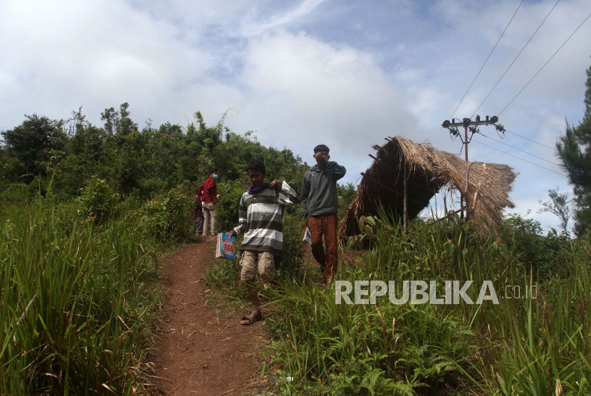 Sejumlah pelajar berjalan usai mengerjakan tugas dengan menggunakan telepon gengam pintar di Jorong Sungai Guntuang, Nagari Pasia Laweh, Kecamatan Palupuah, Kabupaten Agam, Sumatera Barat, Kamis (23/7/2020). Akses internet menjadi kendala utama pada pelaksanaan pembelajaran jarak jauh di era tatanan normal baru bagi pelajar yang tinggal di daerah pelosok di Kabupaten Agam, karena mereka harus berjalan kaki atau menggunakan sepeda motor sejauh delapan km dari rumah untuk mendapatkan jaringan internet. 