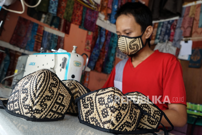 Pekerja menjahit masker berbahan dasar kain dengan lapisan rotan bermotif Dayak di Palangkaraya, Kalimantan Tengah. Badan Standardisasi Nasional (BSN) menetapkan Standar Nasional Indonesia (SNI) 8914:2020 Tekstil – Masker dari kain, di antaranya masker harus memiliki minimal dua lapis kain.