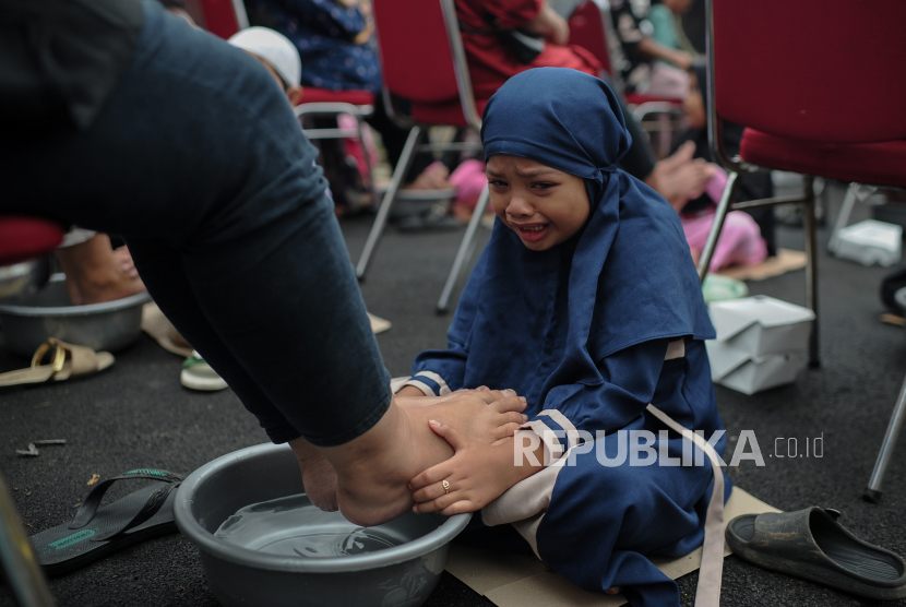 Anak membasuh kaki ibunya untuk meningkatkan cinta kasih kepada ibu.