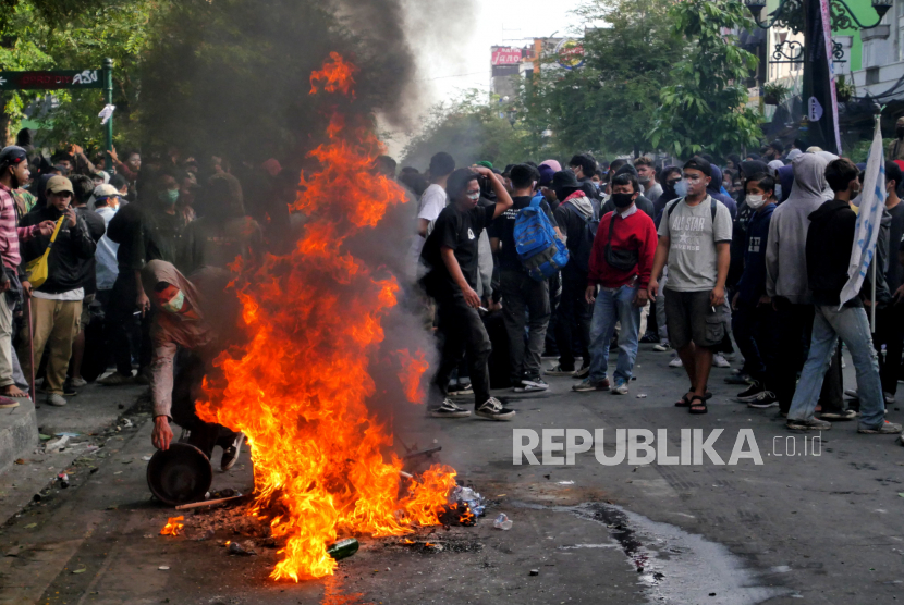 Peserta aksi unjuk rasa tolak Omnibus Law membakar ban di depan DPRD DIY, Kamis (8/10).