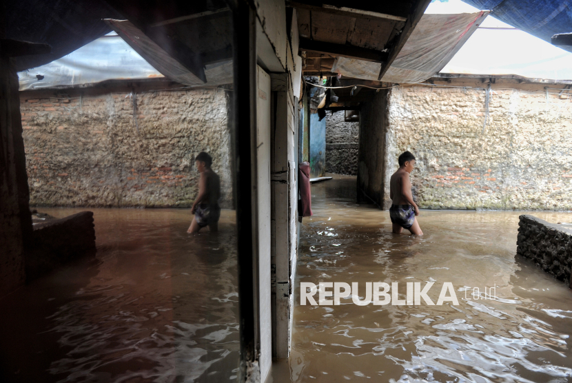 Warga beraktivitas di kawasan pemukiman yang terendam banjir di Kebon Pala II, Jakarta, Kamis (8/1/2025). Banjir setinggi sekitar 40-50 centimeter tersebut terjadi akibat intensitas curah hujan tinggi pada malam dini hari hingga pagi yang menyebabkan debit air Kali Ciliwung meluap hingga ke pemukiman warga.