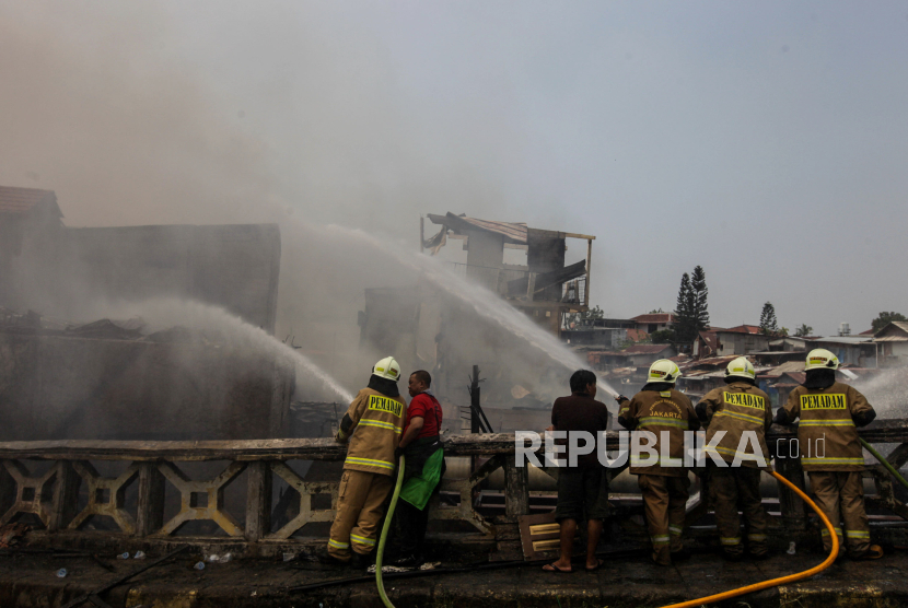 Petugas Damkar memadamkan api yang membakar pemukiman padat di kawasan Manggarai, Jakarta, Kamis (14/12/2023). Kebakaran yang terjadi sekitar pukul 11.00 WIB tersebut membuat 280 jiwa dari 61 KK mengungsi dan belum diketahui penyebab kebakaran tersebut.
