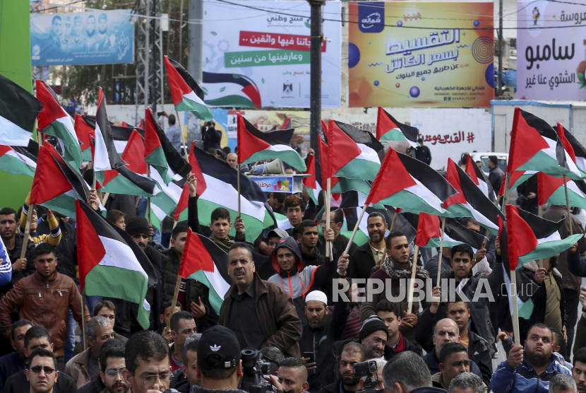  Dalam file foto 21 Februari 2020 ini, warga Palestina mengibarkan bendera nasional mereka selama protes terhadap rencana Timur Tengah yang diumumkan oleh Presiden AS Donald Trump, di Kota Gaza. Ilustrasi.