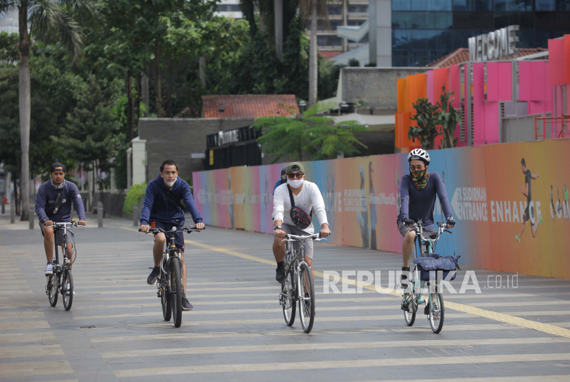 Warga bersepeda dengan tetap menjaga jarak di kawasan Jalan Jenderal Sudirman, Jakarta, Ahad (31/5/2020). Presiden Jokowi meminta segenap pihak beradaptasi dengan tatanan normal baru ini yang sudah disiapkan oleh Kementerian Kesehatan yang kemudian disosialisasikan secara masif kepada masyarakat