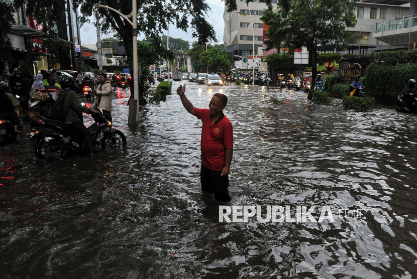 Warga mengatur lalu lintas saat genangan air menutupi Jalan Kemang Raya, Jakarta Selatan, Selasa (5/11/2024). 