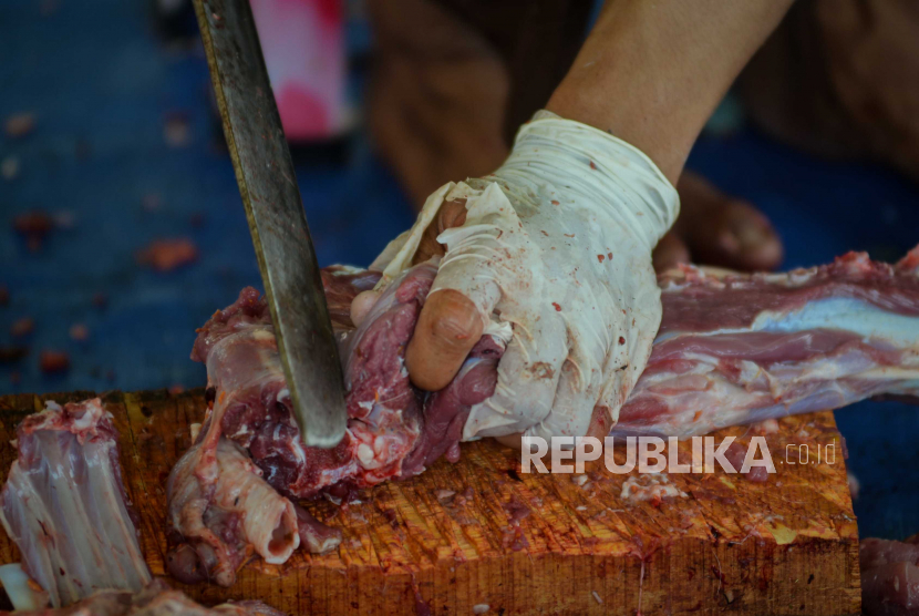 Petugas memotong daging kurban kambing.
