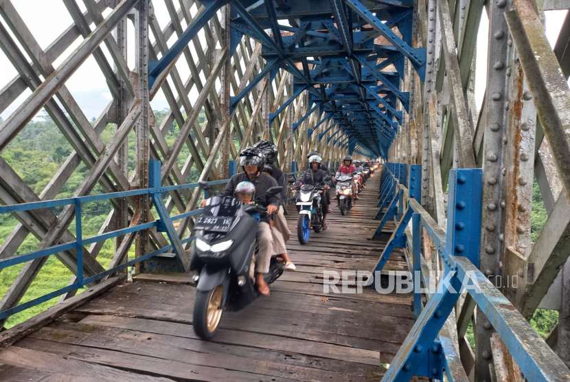 Sejumlah pengguna kendaraan roda dua melintasi Jembatan Cirahong di Kecamatan Manonjaya, Kabupaten Tasikmalaya, Jawa Barat, Sabtu (22/4/2023). Jembatan itu merupakan jalur alternatif yang menghubungkan wilayah Kabupaten Tasikmalaya dengan Ciamis. 
