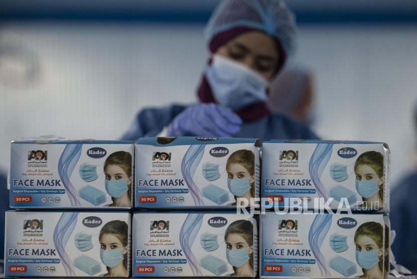  Pekerja di sebuah pabrik yang memproduksi masker bedah, di Kairo, Mesir. Mesir melaporkan peningkatan kasus Covid-19 tertinggi dalam beberapa bulan. Ilustrasi.