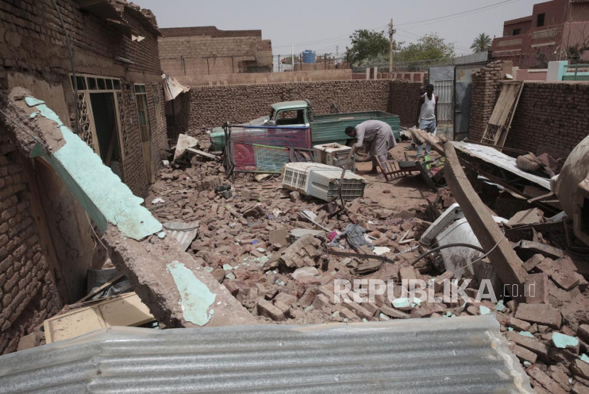  Seorang pria membersihkan puing-puing rumah yang terkena dalam pertempuran baru-baru ini di Khartoum, Sudan, Selasa (25/4/2023). Para jenderal yang bertikai di Sudan telah berjanji untuk mengamati gencatan senjata tiga hari baru yang ditengahi oleh Amerika Serikat dan Arab Saudi untuk mencoba mencabut Negara terbesar ketiga di Afrika dari jurang maut.