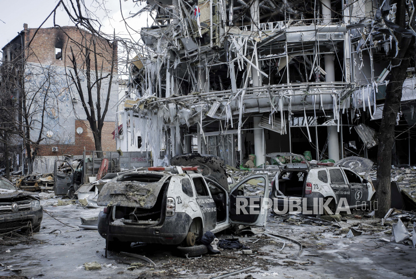  Kendaraan dan bangunan yang rusak di pusat kota Kharkiv di Ukraina, Rabu, 16 Maret 2022. Baik Rusia dan Ukraina memproyeksikan optimisme menjelang putaran pembicaraan lain yang dijadwalkan Rabu, bahkan ketika pasukan Moskow menghujani Kyiv dan kota-kota besar lainnya dalam upaya untuk menghancurkan perlawanan yang telah menggagalkan harapan Kremlin untuk kemenangan kilat.