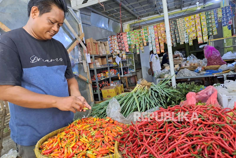 Seorang warga memilih cabai rawit merah yang hendak dibelinya di pasar, (ilustrasi).