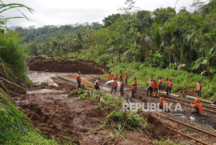 Petugas menyingkirkan longsor yang menutup jalur kereta api di lintas stasiun Karanggandul-Karangsari, Banyumas, Jateng. Penumpang KA di Cirebon dialihkan naik bus imbas dari longsor di Purwokerto.