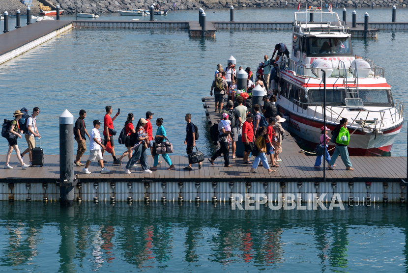 Wisatawan berjalan di dermaga saat akan menaiki kapal cepat di Pelabuhan Sanur, Denpasar, Bali, Jumat (12/4/2024). 