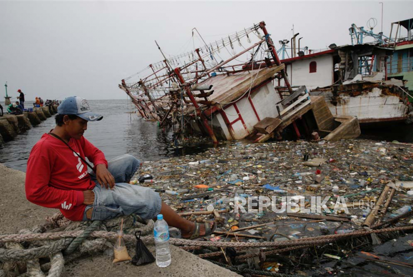 Pemda DKI disarankan tak perlu khawatir soal tipping fee ITF. Foto ilustrasi Seorang penduduk duduk di depan perairan Jakarta yang penuh dengan sampah