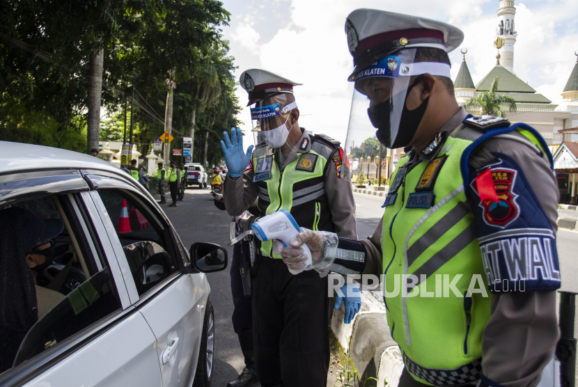 Polisi memerika pengendara yang melintasi perbatasan Daerah Istimewa Yogyakarta dengan Jawa Tengah di Klaten, Jawa Tengah, Minggu (26/4/2020). Pemeriksaan tersebut untuk mengawasi kendaraan yang tidak mengatur jaga jarak dalam kendaraan dan penggunaan masker saat berada di luar ruang guna mengantisipasi penyebaran COVID-19