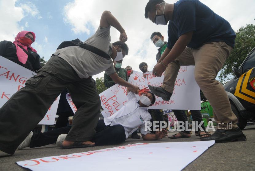 Sejumlah wartawan melakukan aksi teatrikal saat melakukan aksi solidaritas di kawasan Monumen Arek Lancor, Pamekasan, Jawa Timur, Senin (29/3/2021). Mereka menuntut pihak berwajib untuk mengusut tuntas oknum pelaku kekerasan terhadap wartawan Tempo, Nurhadi saat akan meminta konfirmasi kasus suap pajak. 
