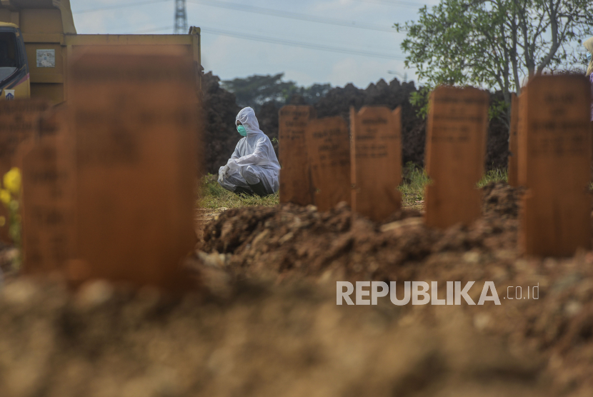 Petugas beristirahat di dekat makam pasien Covid-19 di TPU Rorotan, Jakarta.