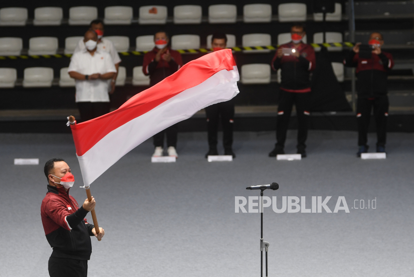 Chef de Mission (CdM) Kontingen Indonesia Ferry J Kono mengibarkan bendera merah putih saat upacara pengukuhan kontingen tim Indonesia untuk SEA Games Vietnam di Jakarta, Ahad (8/5/2022). Tim Indonesia akan memberangkatkan 476 atlet untuk mengikuti 31 cabang olahraga. 