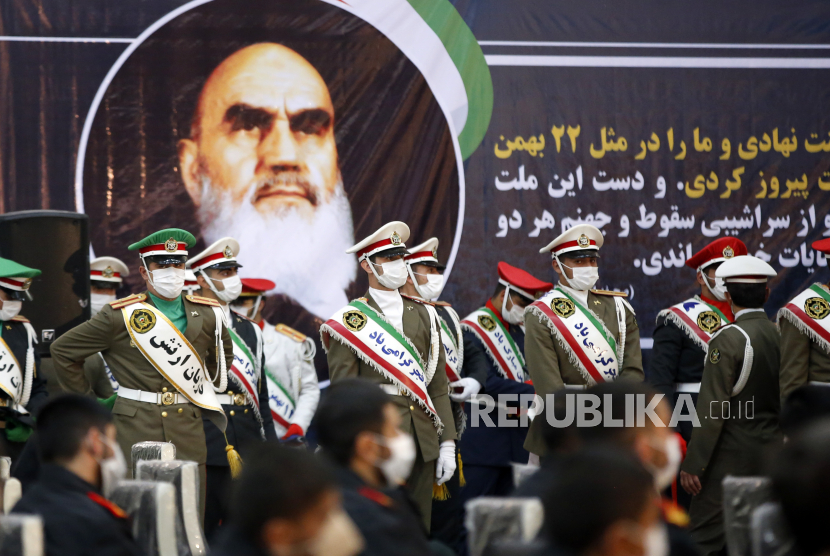  Tentara Iran berdiri di samping foto besar mendiang pendiri Iran dari Republik Islam, Ayatollah Ruhollah Khomeini dalam sebuah upacara dalam rangka peringatan 42 tahun kembalinya Khomeini dari pengasingan dari Paris, di makamnya di Teheran selatan, Iran, Ahad (31/1/2021). 