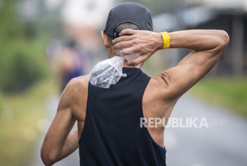 Peserta mendingankan leher saat Maybank Marathon 2022 di kawasan Gianyar, Bali, Ahad (28/8/2022). Sebanyak 10 ribu pelari dari 50 negara mengikuti Maybank Marathon 2022 yang memperlombakan kategori marathon, half marathon dan 10 K dengan total hadiah sebesar Rp 2,4 miliar. 